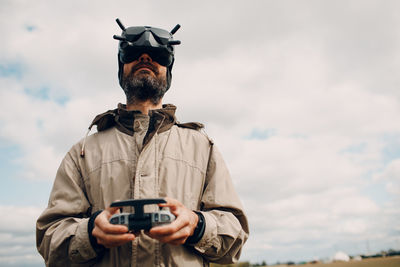 Portrait of man photographing against sky