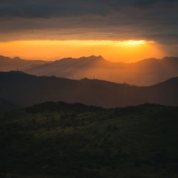 Scenic view of silhouette mountains against sky during sunset