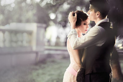 Side view of couple standing in park