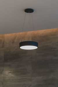 Low angle view of illuminated pendant light hanging from ceiling