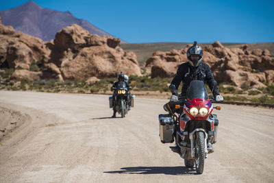 Two friends riding touring motorcycle's on dusty road in bolivia