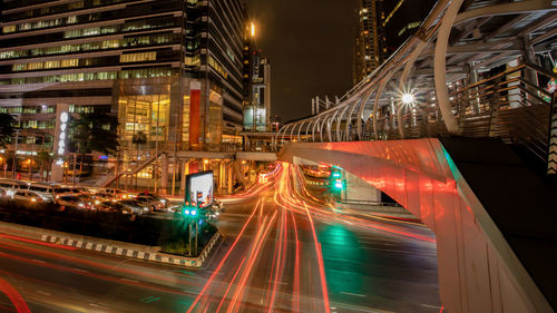 Light trails on city street by buildings at night