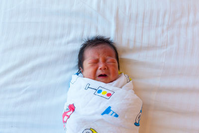 Close-up cute baby sleeping on bed