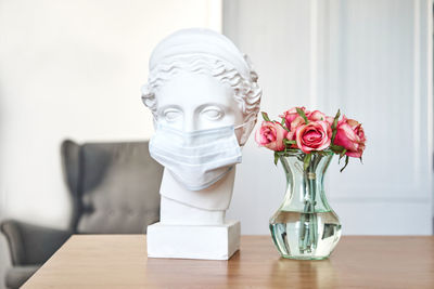 Close-up of white roses in vase on table