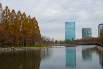 Scenic view of lake by buildings against sky