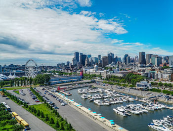 High angle view of city buildings against cloudy sky