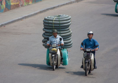 Portrait of people riding motorcycle on road