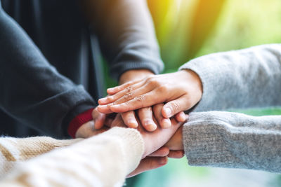 Closeup image of business team standing and joining their hands together in office