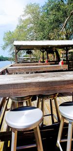 Empty chairs and table in restaurant against sky