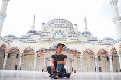 Full length of woman sitting in temple against sky