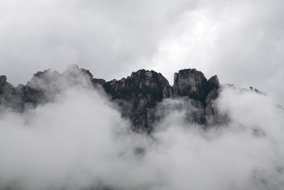 Low angle view of mountain against cloudy sky