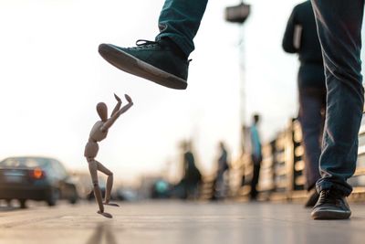 Low section of man stepping on figurine