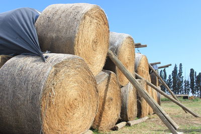 Hay bales on field against clear sky