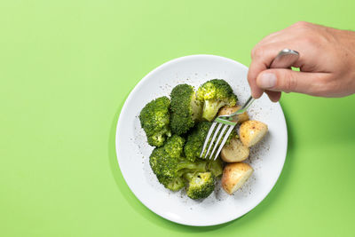 Cropped hand of person holding food in plate