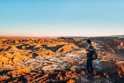 Rear view of man photographing at sunset