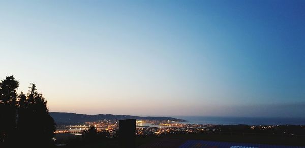High angle view of silhouette buildings against clear sky