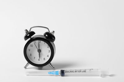 Close-up of clock on table against white background