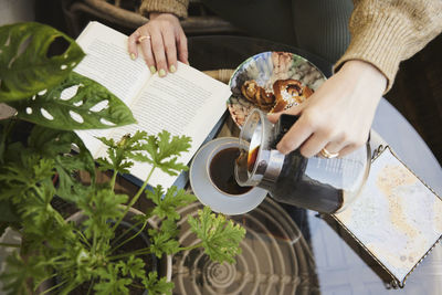 Woman reading book and having tea and snack