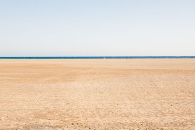 Scenic view of beach against clear sky on sunny day