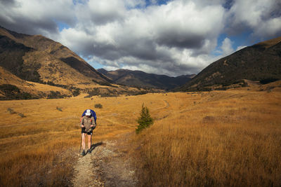 Woman walking on land against sky