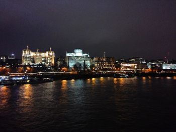 Illuminated city against sky at night