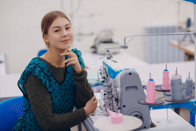 Portrait of woman sitting at sewing factory