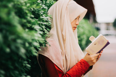 Midsection of woman using mobile phone outdoors