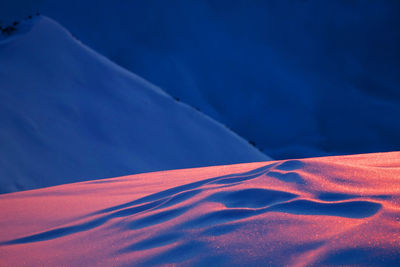 Low angle view of snow against blue sky