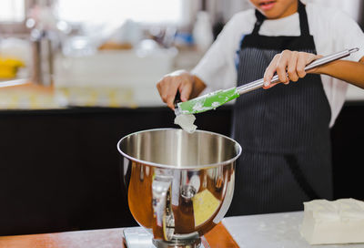 Young boy measuring ingredient for baking in kitchen