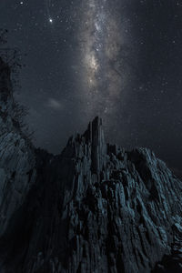 Low angle view of rock formation against sky at night