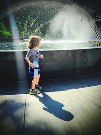 Full length of boy playing on water