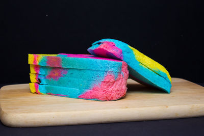 Close-up of multi colored pencils on table against black background