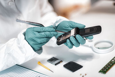 Close-up of man repairing mobile phone