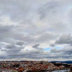 Buildings in city against cloudy sky