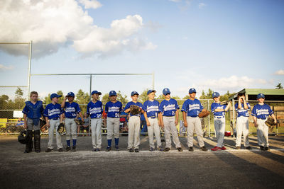 Baseball team standing on field against sky