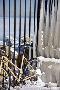 Close-up of bicycle on snow covered railing