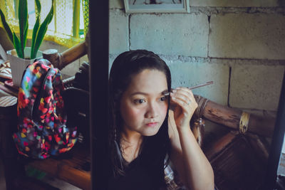 Portrait of young woman looking at home