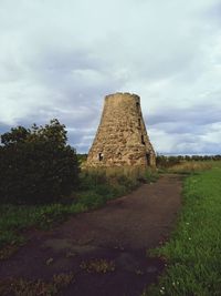 Built structure on field against sky