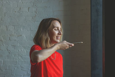 Young woman standing against wall