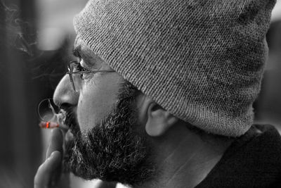 Close-up of bearded man smoking