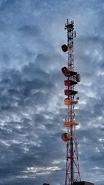 Low angle view of crane against cloudy sky