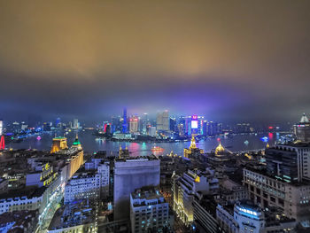 High angle view of illuminated buildings against sky at night