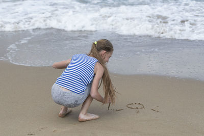 Full length of playful girl on shore at beach
