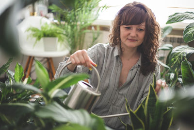 Portrait of young woman holding plant