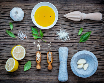 Close-up of lemons and herbs with juicer on table