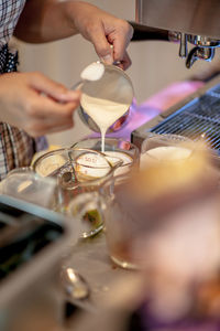 Midsection of barista making coffee in cafe