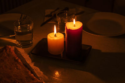 Close-up of lit candle on table