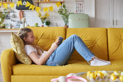 Portrait of woman sitting on sofa at home
