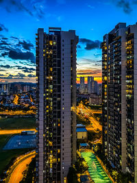 High angle view of illuminated buildings in city at dusk