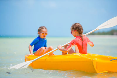 Siblings and boat in sea